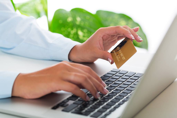 Zbliżenie kobiety pisania na laptopa i posiadania karty kredytowej - Zdjęcie, obraz