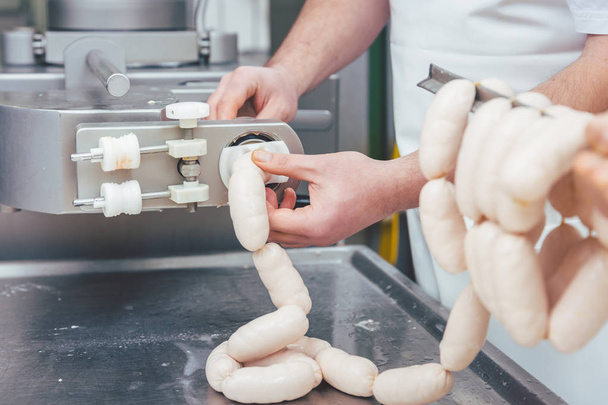 Butcher in butchery filling sausages - Fotoğraf, Görsel