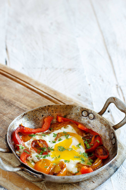 Paistettu muna paprikalla ja tomaatit vanhalla paistinpannulla
  - Valokuva, kuva