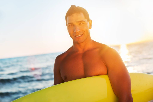 Surfer holding a surfboard - 写真・画像