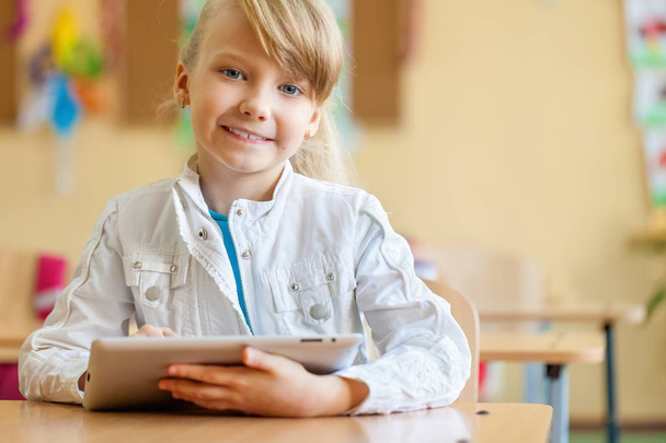 Sonriente joven en un aula usando una tableta
 - Foto, imagen