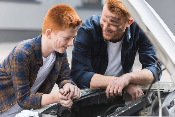 happy father and son repairing car with open hood - Φωτογραφία, εικόνα