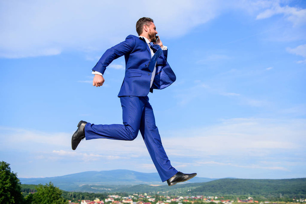Never stop. Businessman formal suit jump while call smartphone sky background. Entrepreneur in motion success expression. Keep going towards your goal. Businessman solving business problems on phone - Fotó, kép