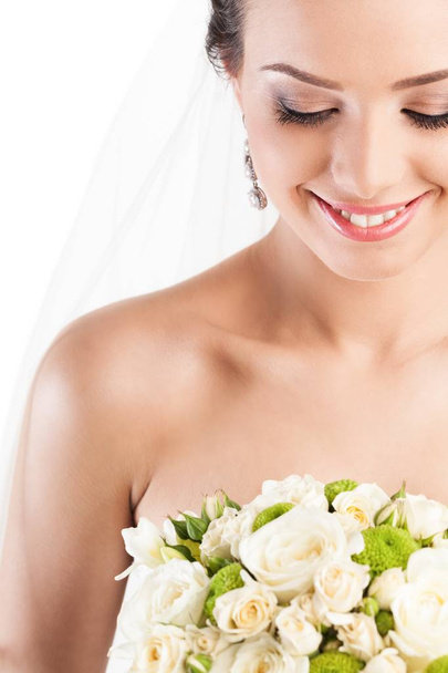 Beautiful bride holding bouquet of flowers isolated on white background - Foto, Bild