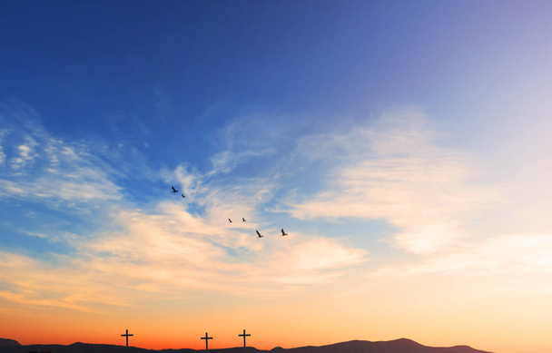 Kristus Jeesus syntymän ja ylösnousemuksen käsite: Siluetti risti Golgatalla vuoren auringonlaskun taustalla
 - Valokuva, kuva
