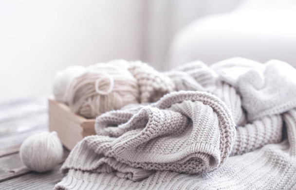 hobby casalinghi, maglioni a maglia accoglienti con una palla di filato nel soggiorno su uno sfondo di legno
 - Foto, immagini