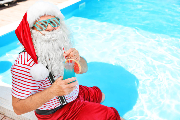 Authentic Santa Claus with cocktail near pool at resort - Φωτογραφία, εικόνα