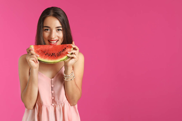 Beautiful young woman posing with watermelon on color background - Фото, изображение