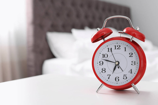 Alarm clock on table in bedroom. Time to wake up - Zdjęcie, obraz