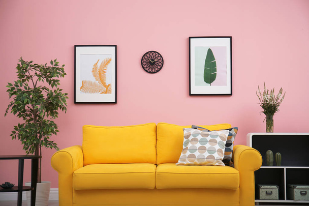 Modern living room interior with comfortable yellow sofa near color wall - Photo, image