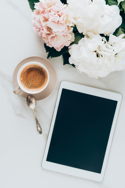 vue du dessus de la tasse avec café expresso, fleurs d'hortensia et tablette numérique avec écran blanc sur la surface du marbre
 - Photo, image
