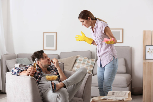 Leniwy mąż kłótnie z pracowita żona w domu - Zdjęcie, obraz
