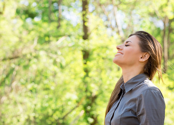 Side view of happy woman taking deep breath and closing eyes enjoying freedom and nature summer vacation  - Foto, Imagen