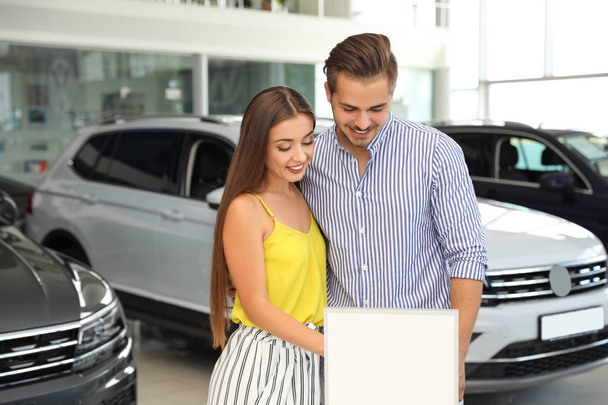 Young couple choosing new car in salon - Photo, image