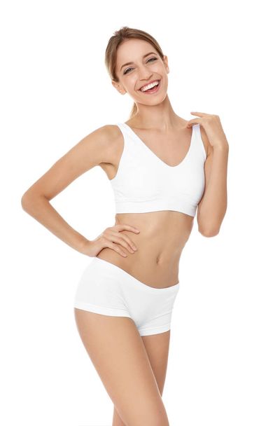 Happy young woman in underwear satisfied with her diet results, isolated on white - Photo, image