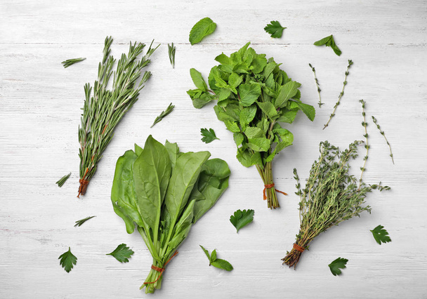Flat lay composition with fresh green herbs on white wooden background - Foto, imagen