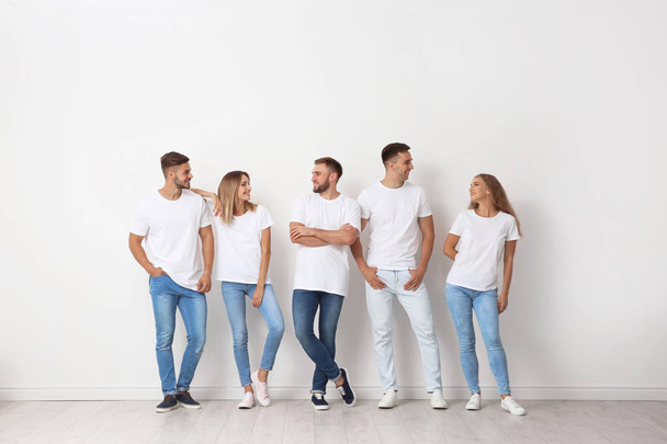 Group of young people in jeans near light wall - Fotografie, Obrázek