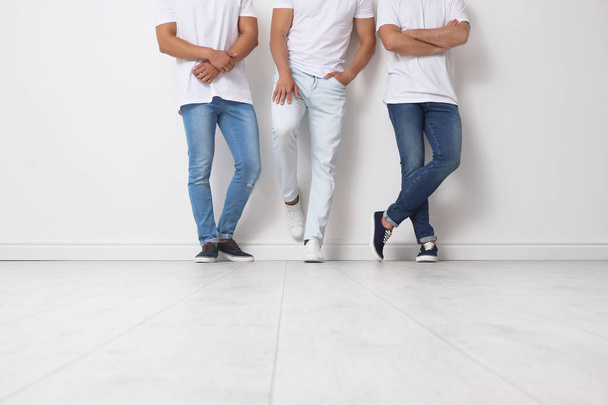 Group of young men in jeans near light wall - Foto, Imagem