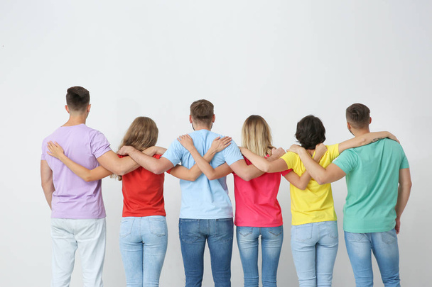 Group of young people hugging each other on light background. Unity concept - Foto, afbeelding