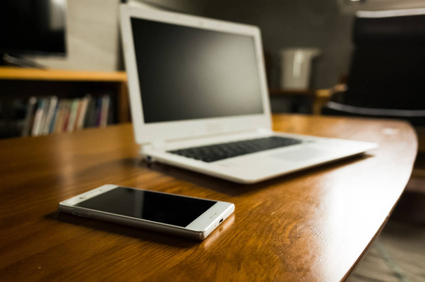 portátil y smartphone sobre la mesa sin nadie, concepto de trabajo en casa
 - Foto, Imagen