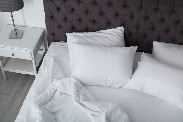 Zachte witte kussens op comfortabele bed binnenshuis - Foto, afbeelding