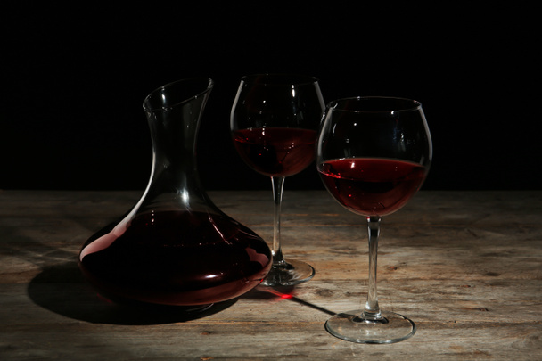 Elegáns decanter és pohár vörösborral asztal sötét háttér - Fotó, kép