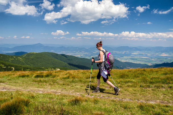 Hiking girl with backpack and trekking poles in Low Tatras mountains, Slovakia - Photo, Image