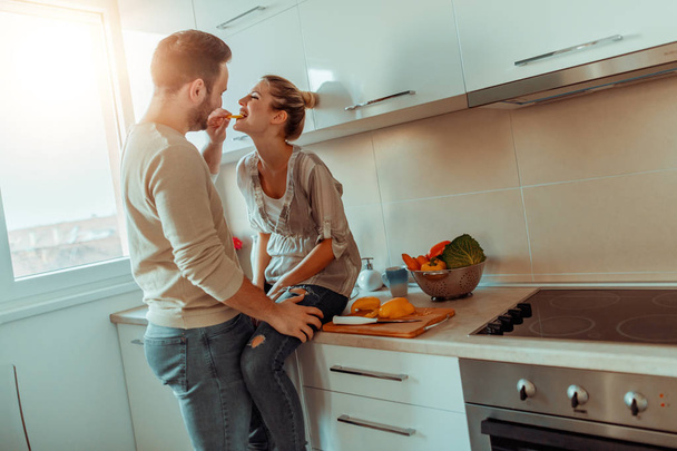 Romántica pareja joven cocinando juntos en la cocina.Pareja joven cortando verduras en la cocina
. - Foto, imagen