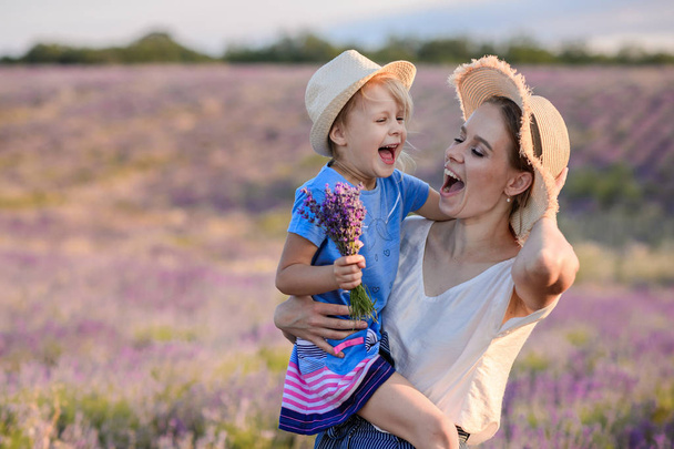 Mom and girl walk on the lavender field. - Photo, Image