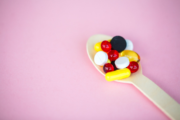 Medische Concept. Gekleurde pillen en capsules op roze achtergrond. Apotheek thema, Capsule pillen met geneeskunde antibioticum in pakketten. - Foto, afbeelding