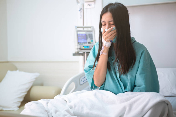 νεαρή γυναίκα ασθενής κάθεται στο κρεβάτι στο νοσοκομείο - Φωτογραφία, εικόνα
