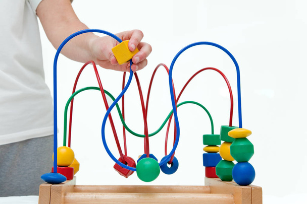 Ξύλινο πολύχρωμο παιχνίδι. Labirinth εκπαιδευτικές παιχνίδι με το χέρι ενήλικα - Φωτογραφία, εικόνα