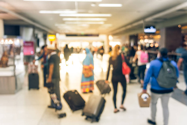 モーションは、モーションの人がアメリカの空港で荷物を持って歩いてをぼやけています。抽象的なぼやけた乗客やバッグ、背面の観光客。廊下のターミナル、朝ライトのバックライトで多重旅行者 - 写真・画像