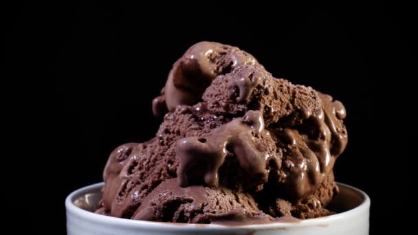 Csokoládé fagylalt és csokoládé szósszal, a fekete háttér. Stúdió-hajtás. - Felvétel, videó