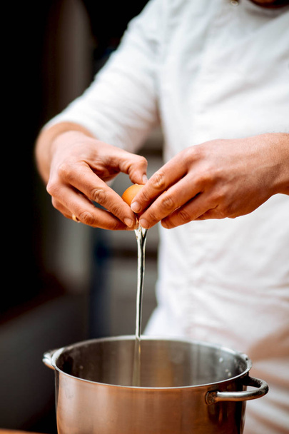Manos de hombre chef romper el huevo en la cocina en la cocina
 - Foto, imagen