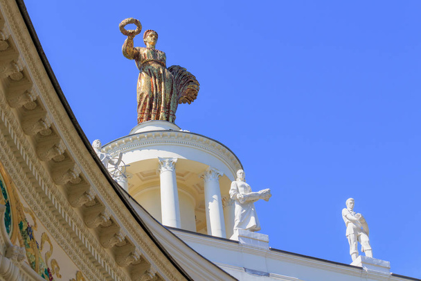 Moscow, Russia - August 01, 2018: Figure of woman of collective farmer on a blue sky background on a roof of pavilion Republic Of Belarus on Exhibition of Achievements of National Economy (VDNH) in Moscow - 写真・画像