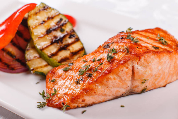 Kırmızı sıcak ve baharatlı fileto balık. Izgara biftek somon veya alabalık ızgara kırmızı biber ve kabak ile. Sağlıklı gıda, deniz ürünleri ve sebze. - Fotoğraf, Görsel