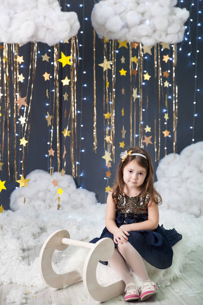 Girl in a studio with a gold stars decor - Fotó, kép