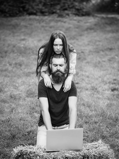 Adorable woman and bearded man using laptop on nature - Fotografie, Obrázek