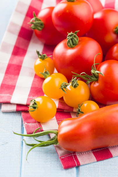 Tasty various tomatoes on checkered napkin. - Foto, Imagen
