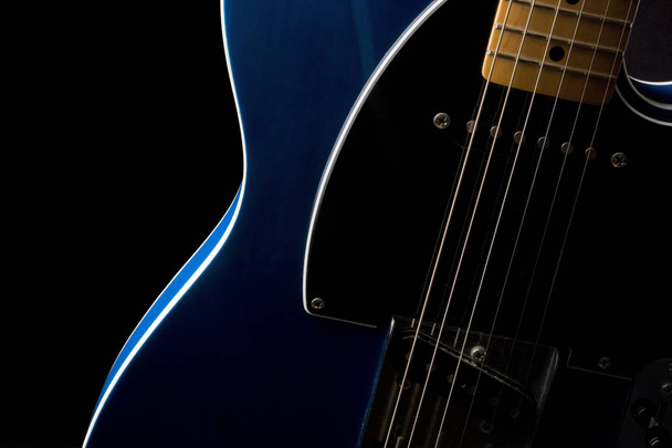 Seção de um corpo de guitarra elétrica e pescoço em close-up com luz lateral forte
 - Foto, Imagem
