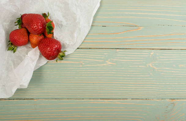 Świeże truskawki piękny stary Vintage drewniane tła i papieru z lato. Niebieski stół z drewna biurko zarządu tekstury z dojrzałych jagód widok z góry - Zdjęcie, obraz