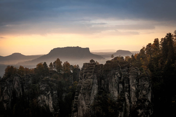 Grande luce mattutina con nebbia e nuvole nel parco nazionale tedesco della Svizzera sassone vicino a Dresda. Escursioni e arrampicate nelle meravigliose catene montuose delle montagne di arenaria dell'Elba
. - Foto, immagini