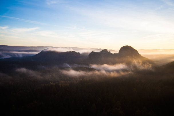 壮大な日の出、メサ ドイツ ザクセン ・ スイス国立公園でのピーク時に光。光と霧の山並み。ハイキング、エルベ砂岩山地のすばらしい山脈で登山. - 写真・画像