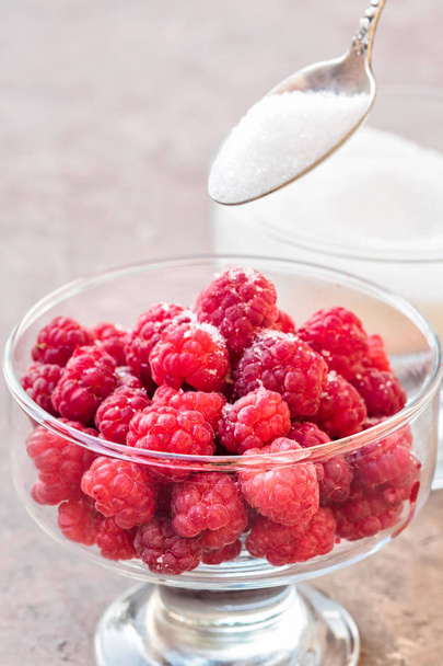 Glass of fresh raspberries sprinkled with white sugar gardening gastronomy harvest summer evening sunset light Concept home made ingredient recipe for cooking jam and cookware - Fotoğraf, Görsel
