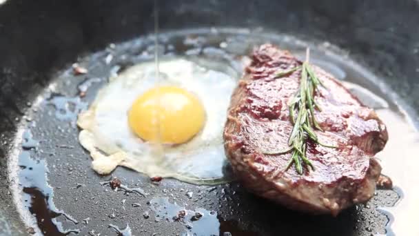 Delicious steak with egg and rosemary cooking on pan. - Footage, Video