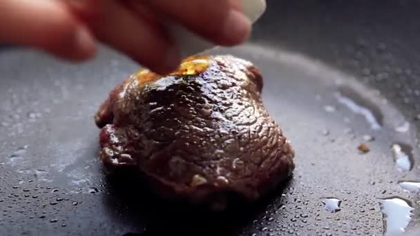 Cooking raw steak with oil and rosemary on pan. - Felvétel, videó
