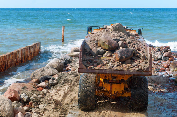 Μηχανήματα κατασκευής στην ακτή, την κατασκευή κυματοθραυστών, μέτρα προστασίας των ακτών - Φωτογραφία, εικόνα