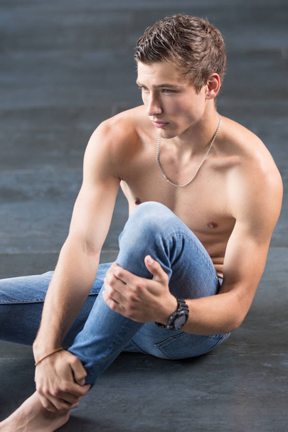 Handsome young male model on the floor shirtless looking dreamy - Fotografie, Obrázek