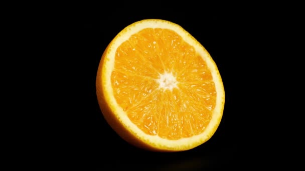 Een halve sinaasappel tegen zwarte achtergrond - Video